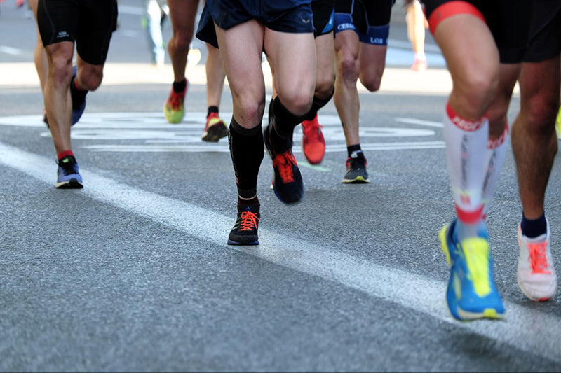 Close-up of the legs of a group of participants in a running race.